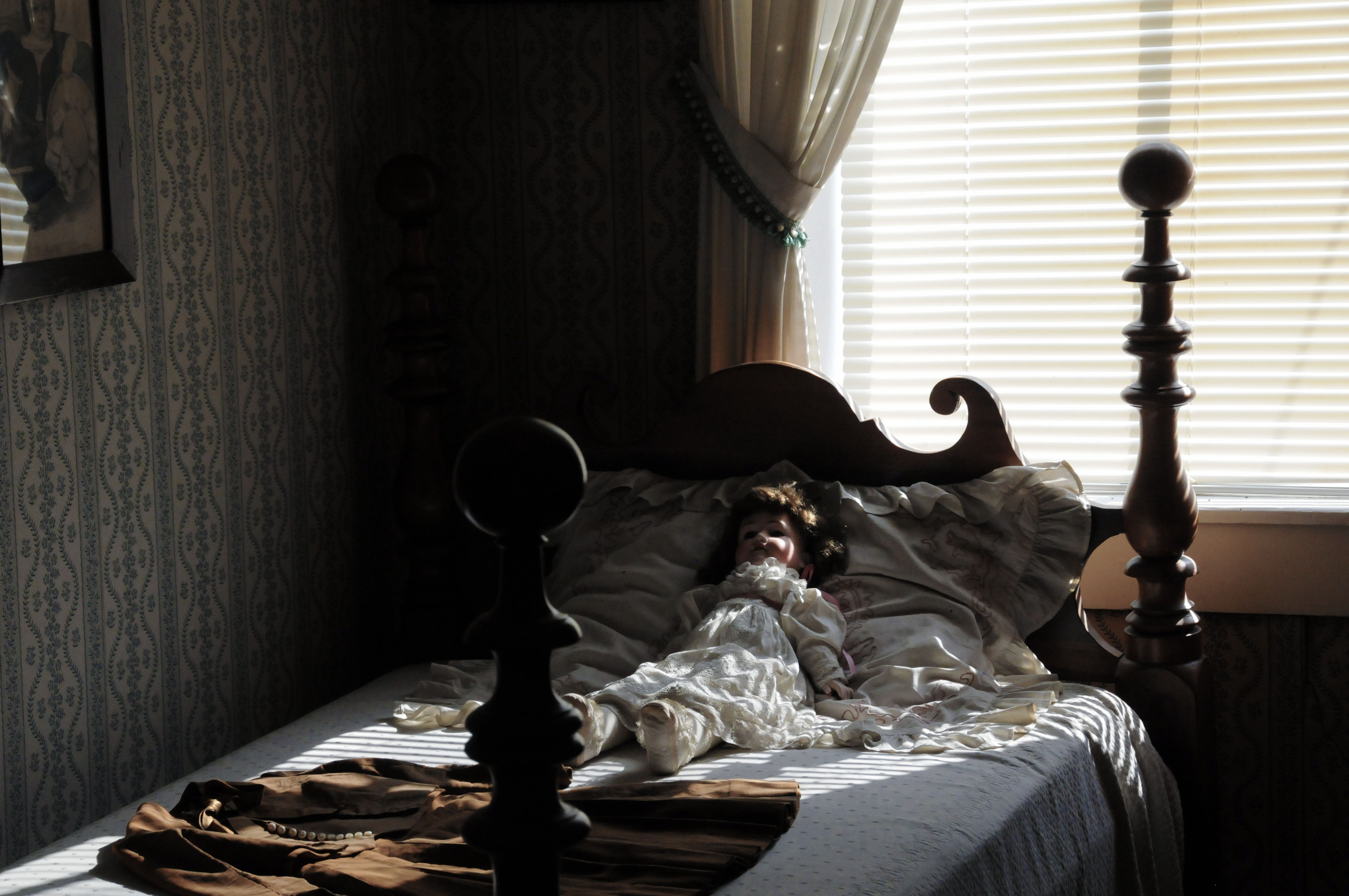 Doll sitting on bed in Sarah's Room at the Golden Lamb